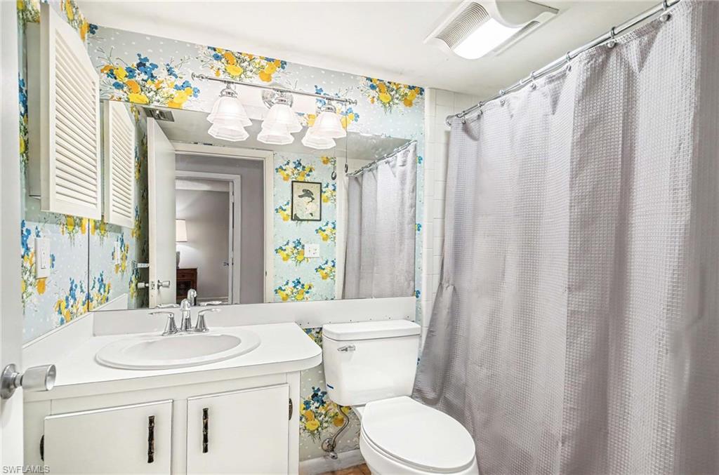 Vanity with integrated sink, wall-mounted mirror, and overhead lighting fixture