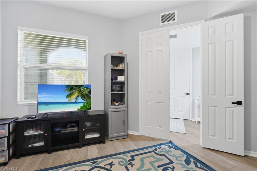 Wood-finish flooring, ceiling fan, Double doors and window with horizontal blinds