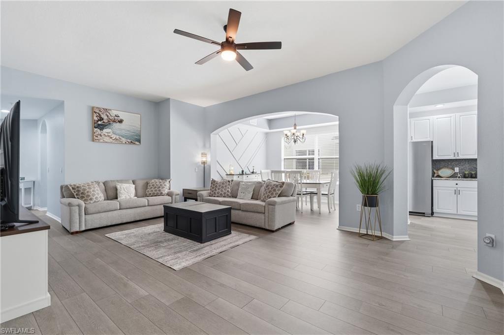 Open-concept living area featuring engineered wood-finish flooring throughout, recessed ceiling lighting, and a ceiling fan with integrated light fixture
