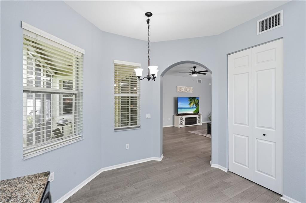 Wood-finish flooring, bi-fold closet doors, arched doorway, and recessed ceiling lighting