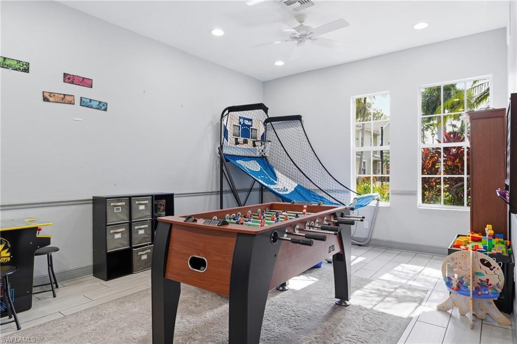 Recessed lighting, ceiling fan, crown molding, white tile flooring, and multiple windows