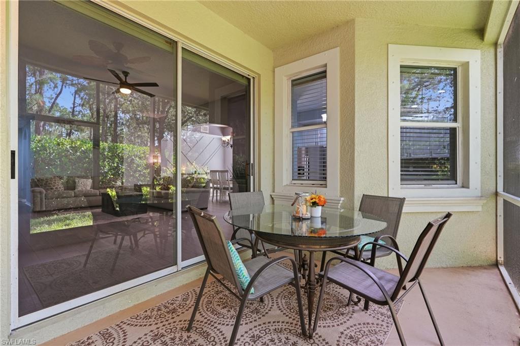 Screened lanai featuring a textured stucco exterior, multiple windows with blinds, and sliding glass doors