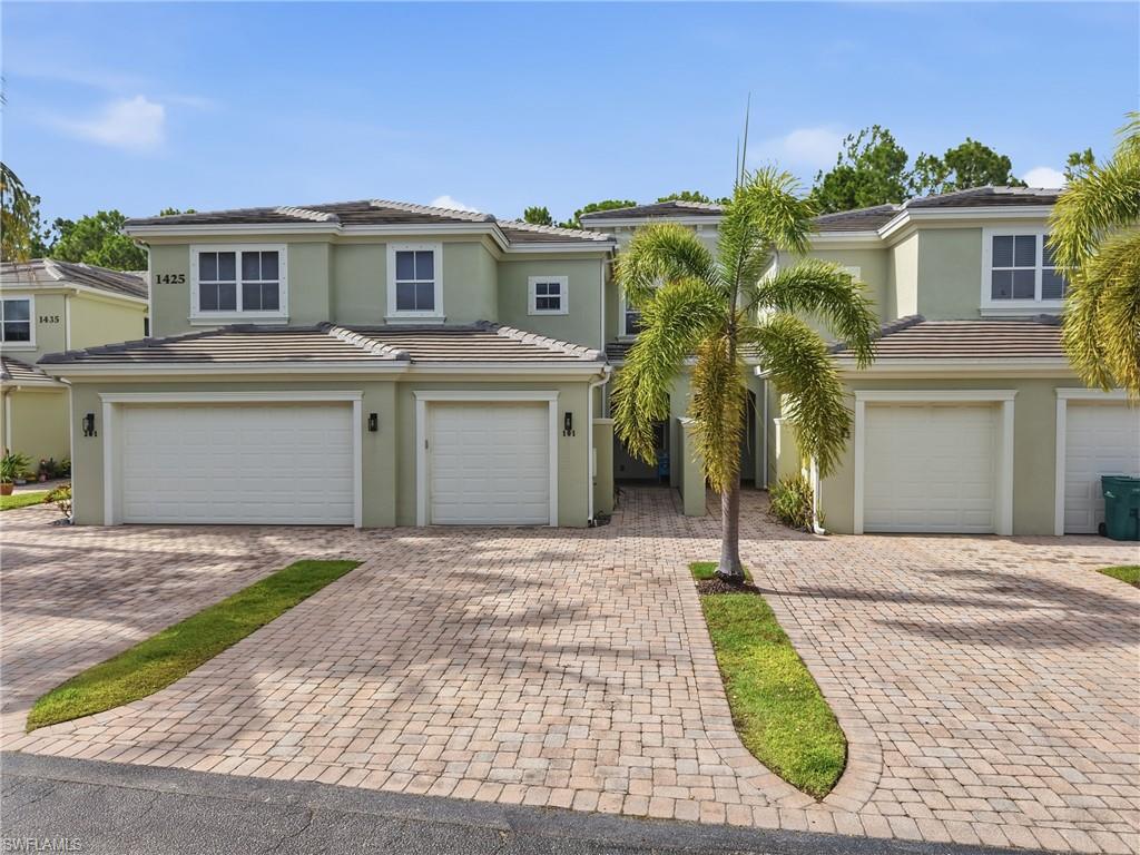 Stucco exterior with a tiled roof, paver driveway, and an attached one-car garage
