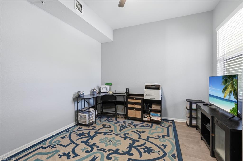 Wood-finish flooring, ceiling fan, and window with horizontal blinds