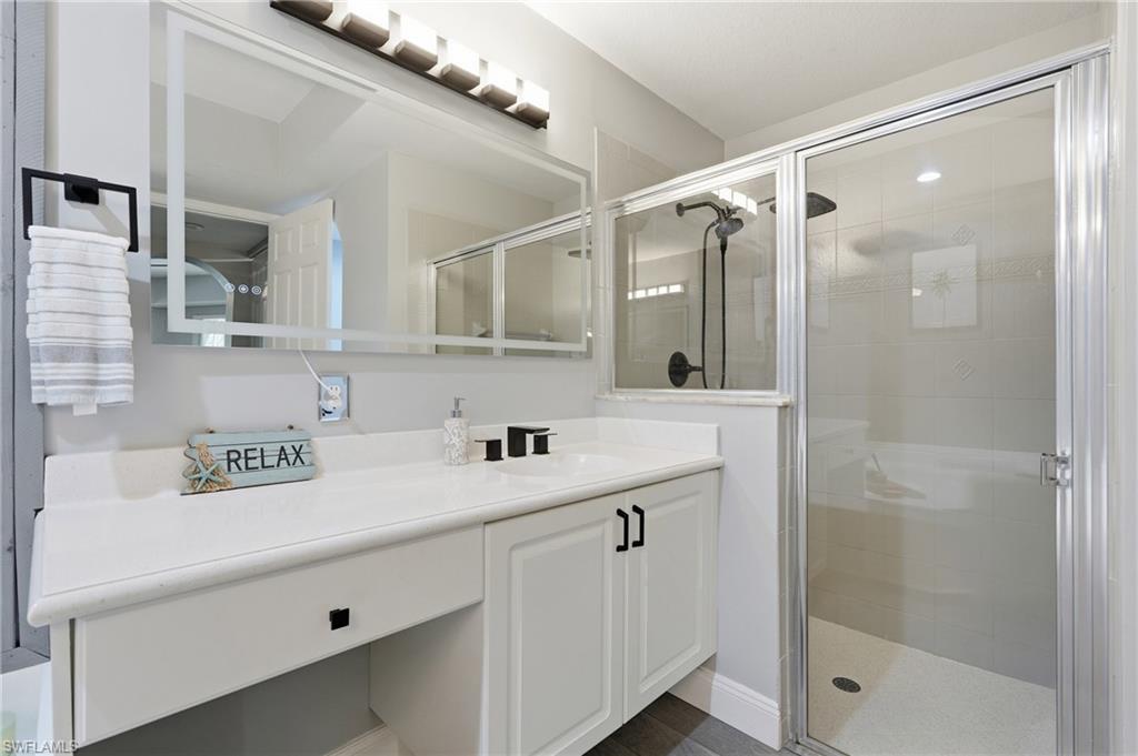 Vanity with integrated sink, white cabinetry, and matte black fixtures