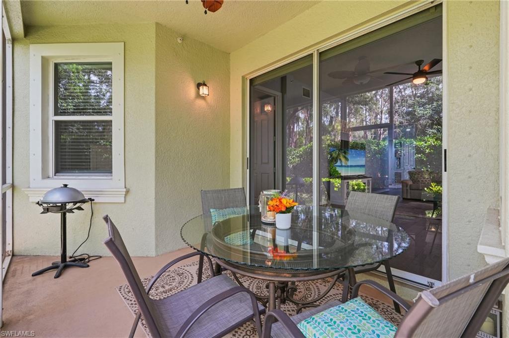Screened lanai featuring a textured stucco exterior, multiple windows with blinds, and sliding glass doors