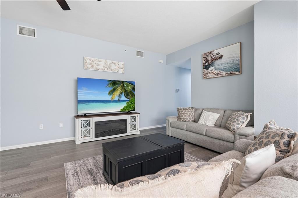 Open living area with wood-finish flooring, light-toned wall paint, and recessed ceiling fan