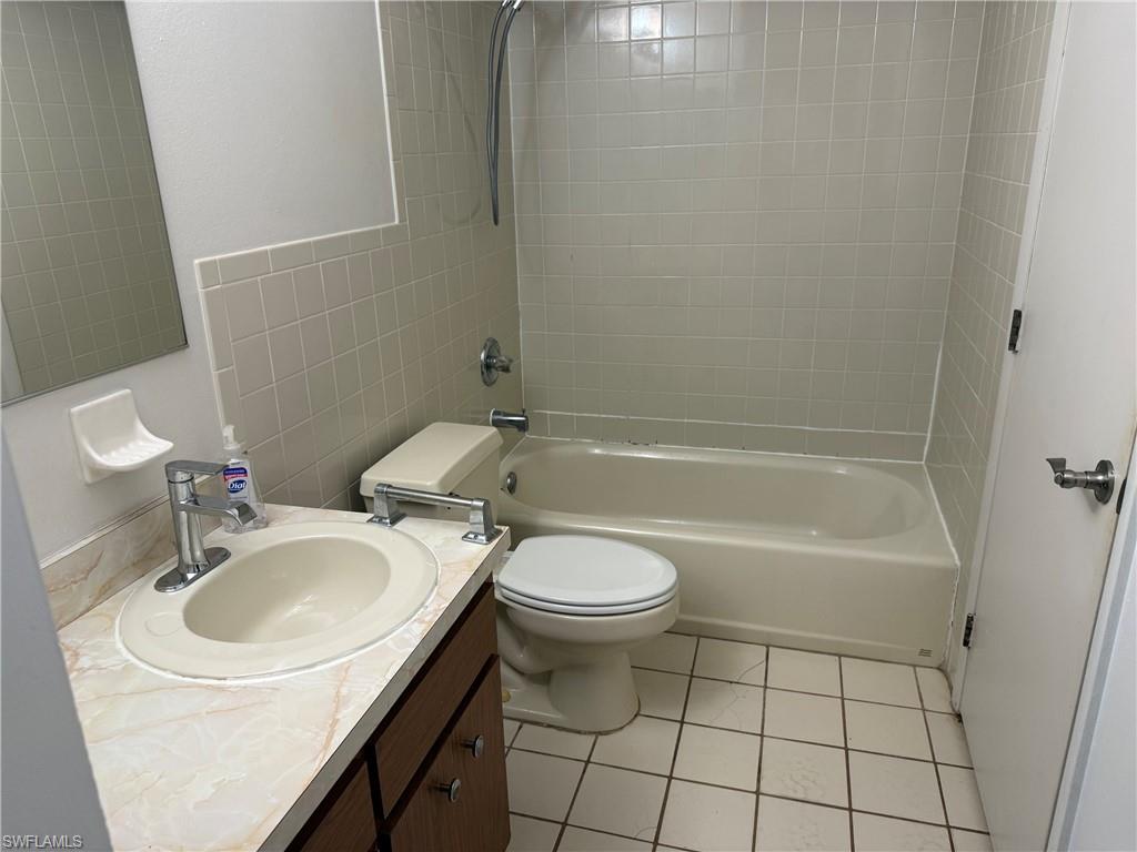 Full bathroom featuring a vanity with an integrated sink, polished chrome faucet, and a bathtub with an overhead shower