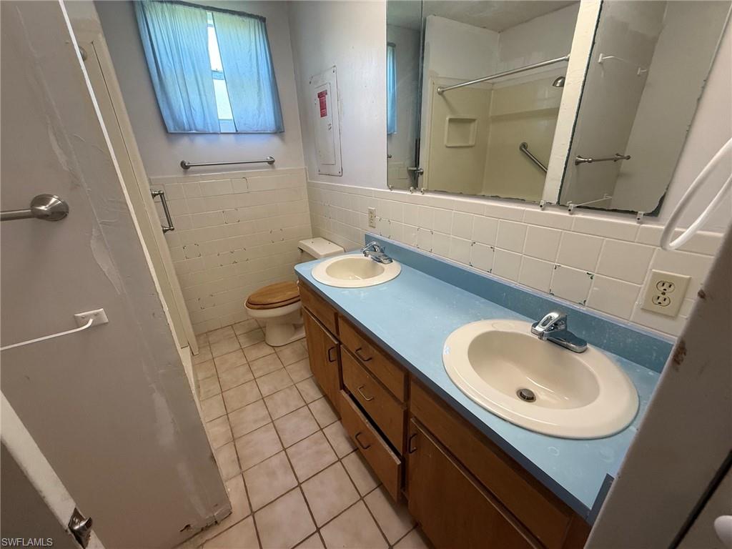 Dual vanity with integrated sinks, wood-finish cabinetry, and a blue countertop