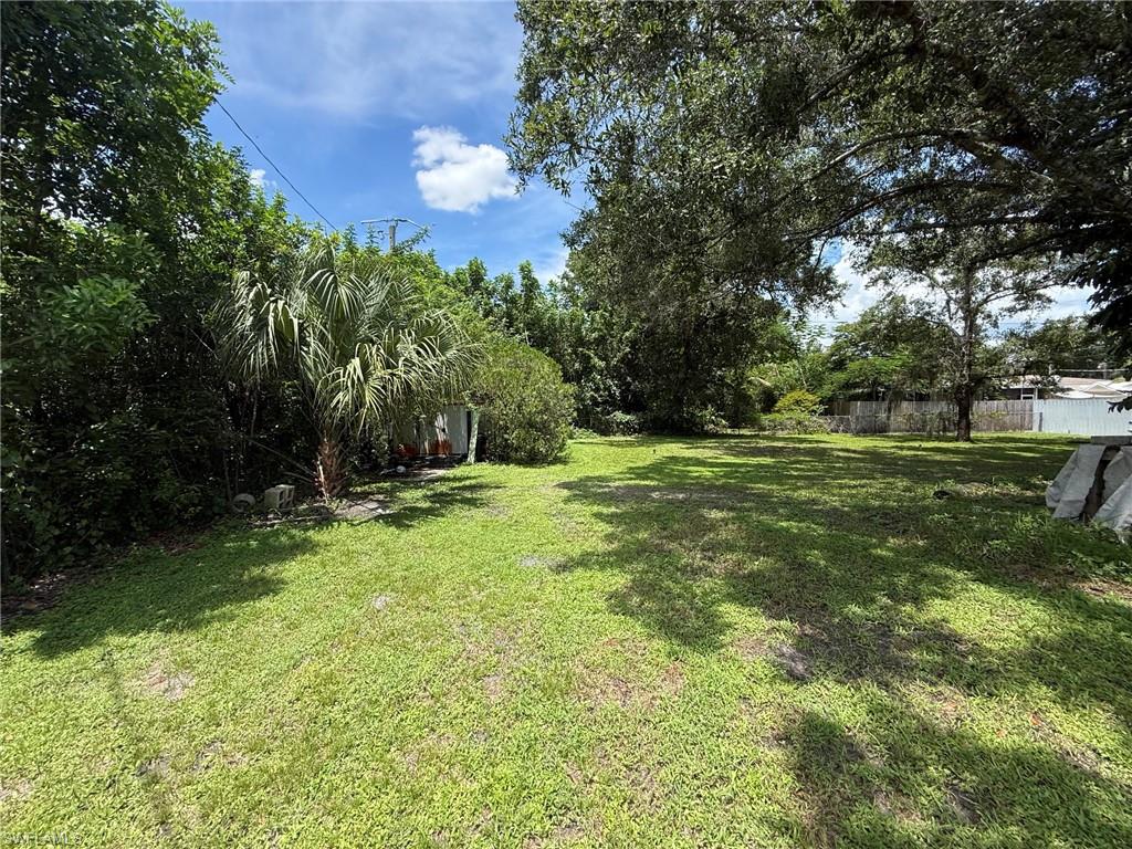 Expansive green lawn with mature trees and established perimeter foliage