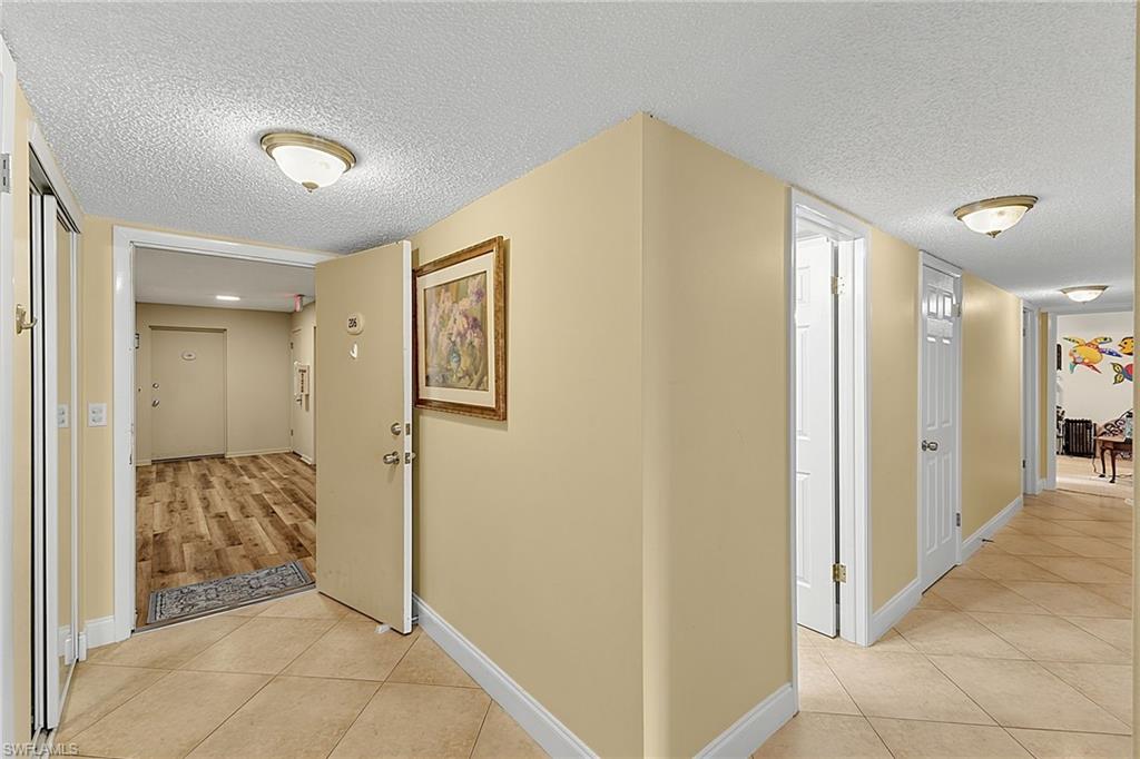 Entry area with neutral painted walls and a textured ceiling