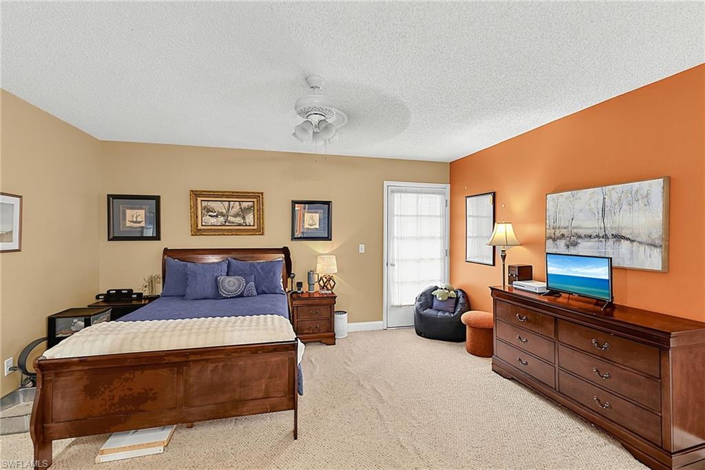 Carpeted room featuring a ceiling fan, a painted accent wall, and a door with louvered blinds