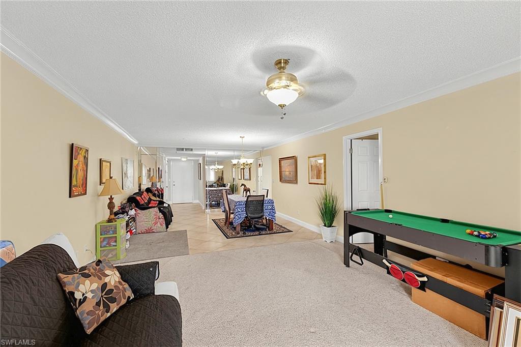 Open concept living space featuring crown molding and beige wall tones