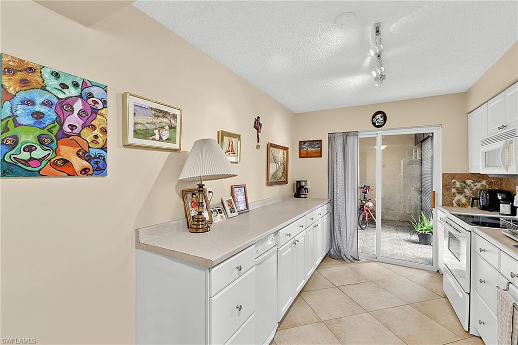 Kitchen featuring white cabinetry, light-toned countertops, and diagonal-set tile flooring