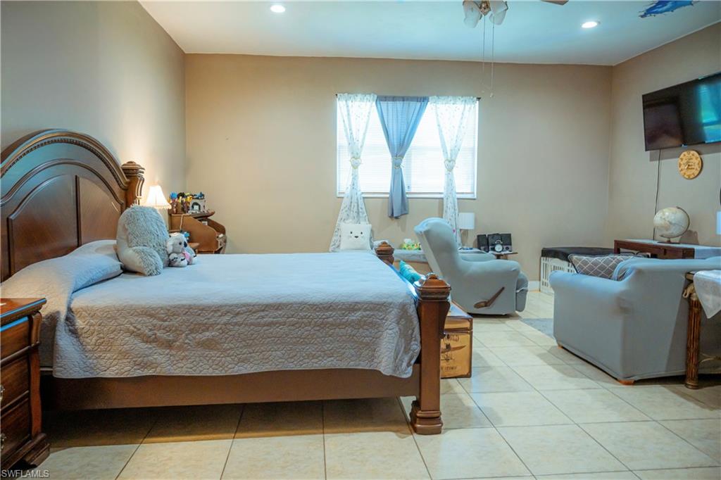 Recessed lighting, window with light-filtering curtains, and tile flooring