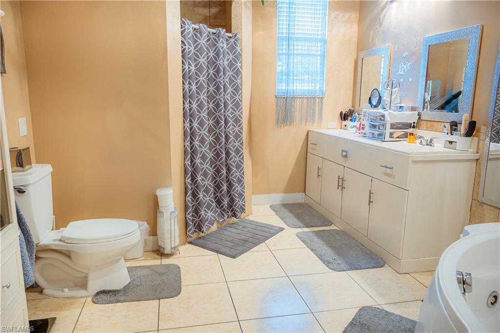 Built-in vanity with dual sinks, overhead lighting, and storage cabinetry