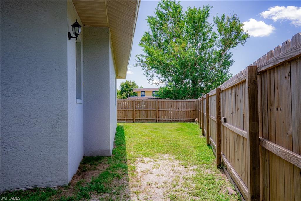 Private backyard featuring a wood privacy fence and mature landscaping