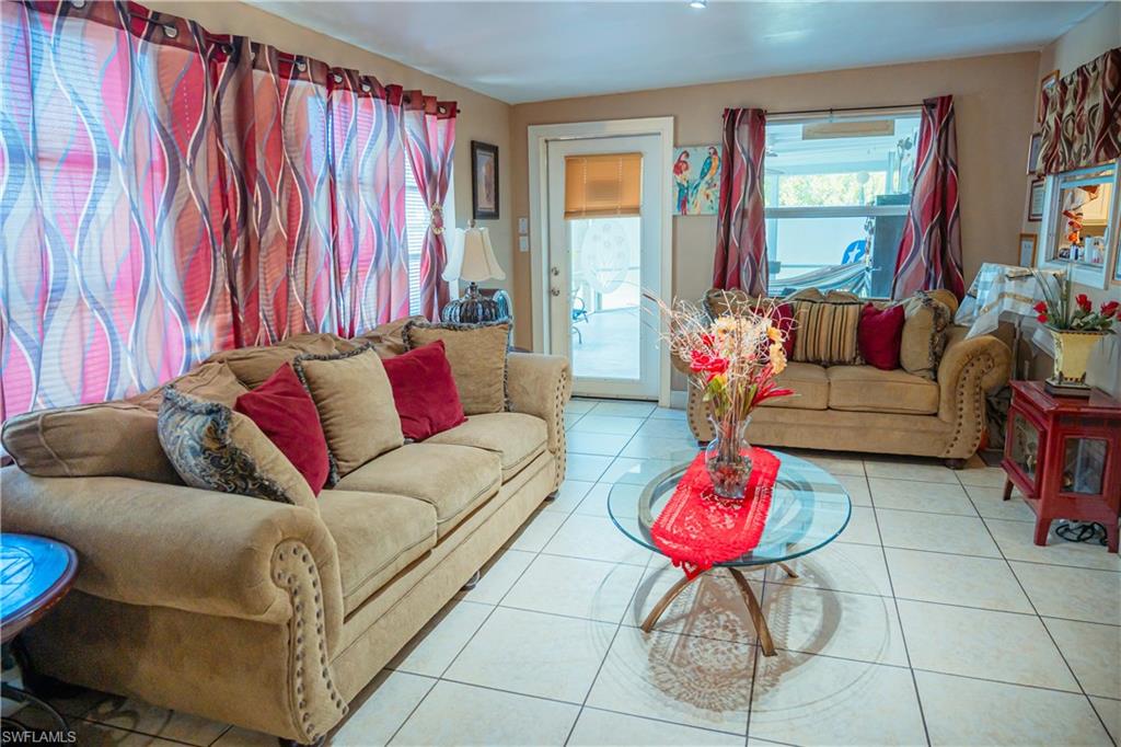 Tiled flooring throughout, featuring a glass-top coffee table and a rear exterior door