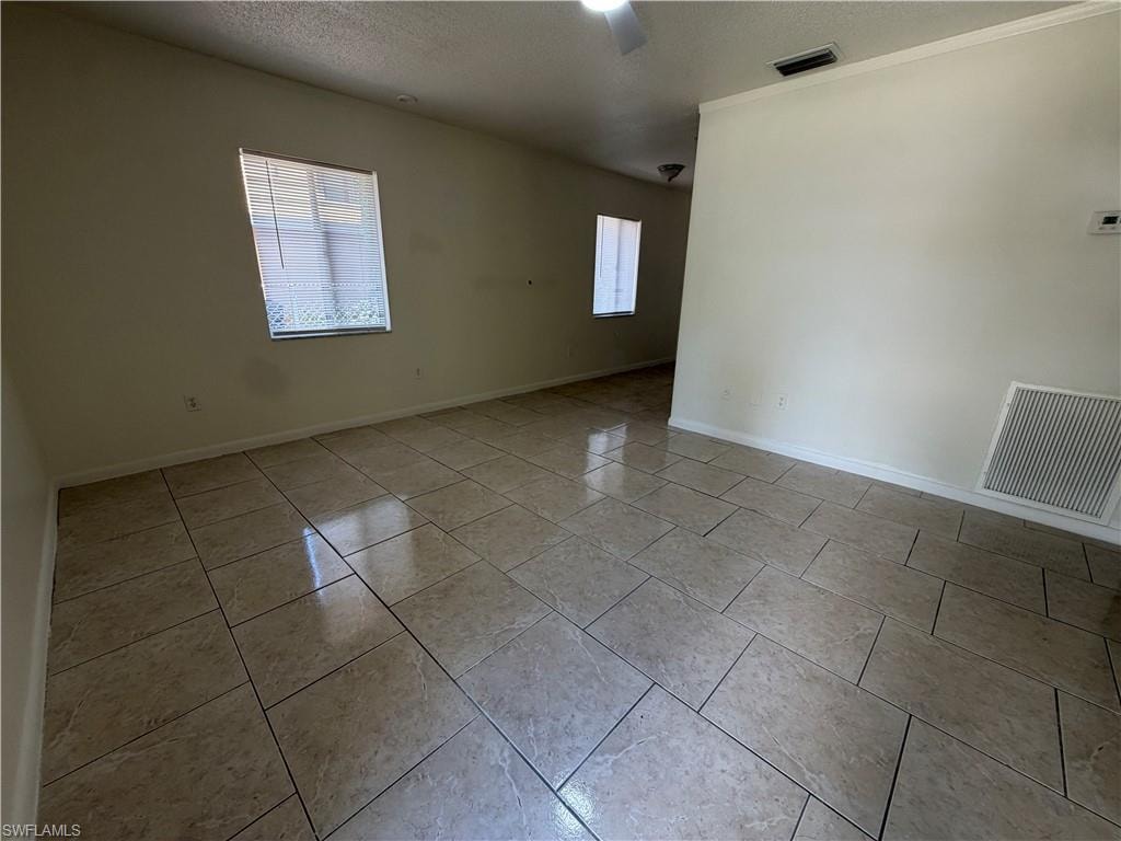 Neutral-toned tile flooring, light-colored walls, and multiple windows with blinds