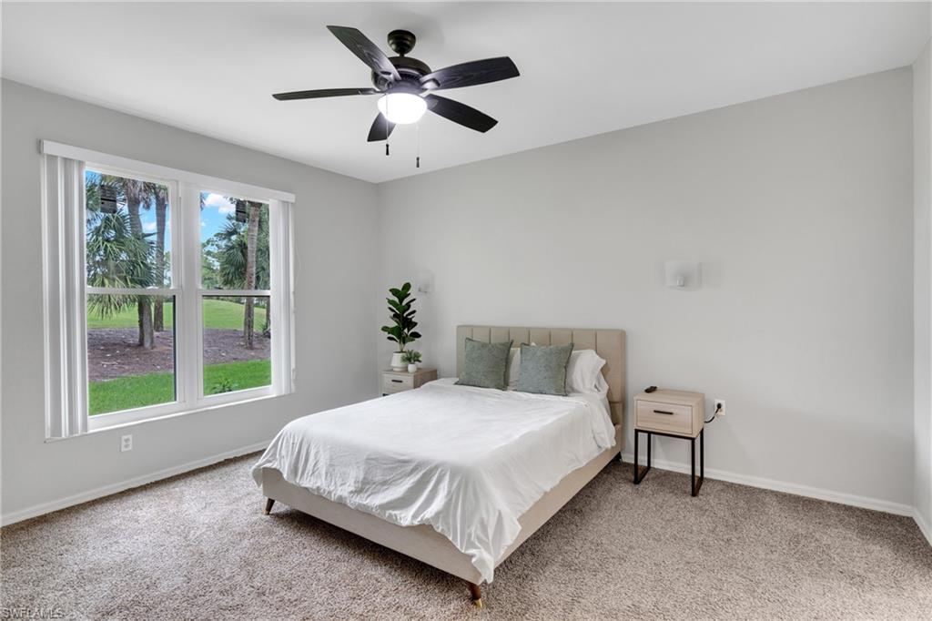 Gray carpet flooring, white walls, double window, ceiling fan with integrated lighting, wall-mounted light fixture