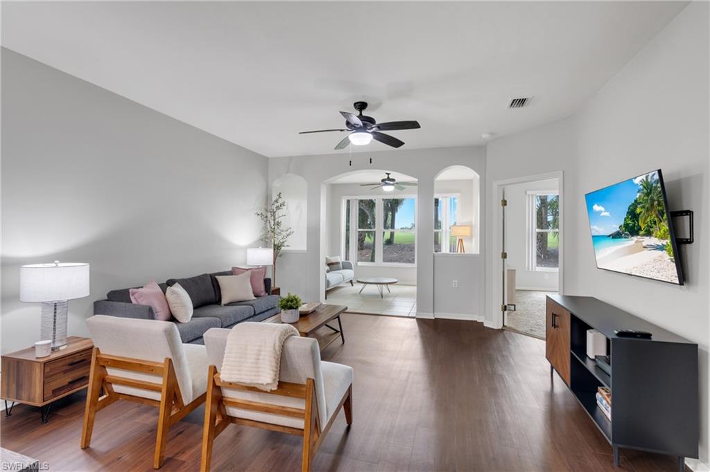 Wood-finish flooring, light gray wall tones, and recessed lighting create a bright living space