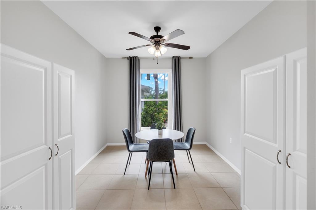 Recessed ceiling, ceiling fan with integrated lighting, tiled flooring, built-in white panel cabinetry, and a window with natural light