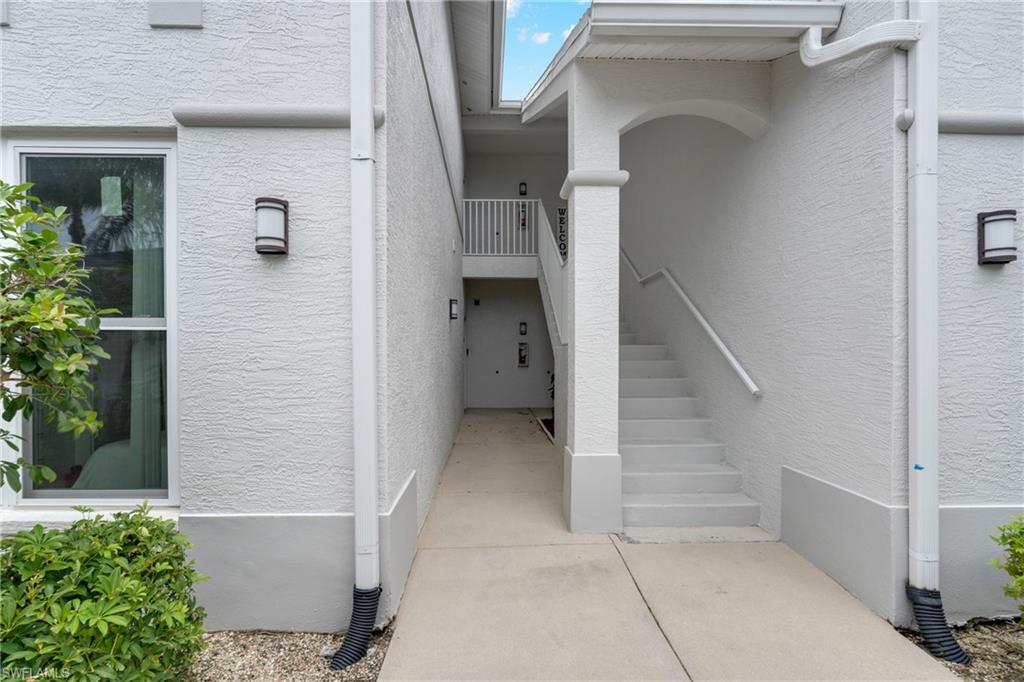 Stucco exterior with recessed lighting fixtures and a covered entryway