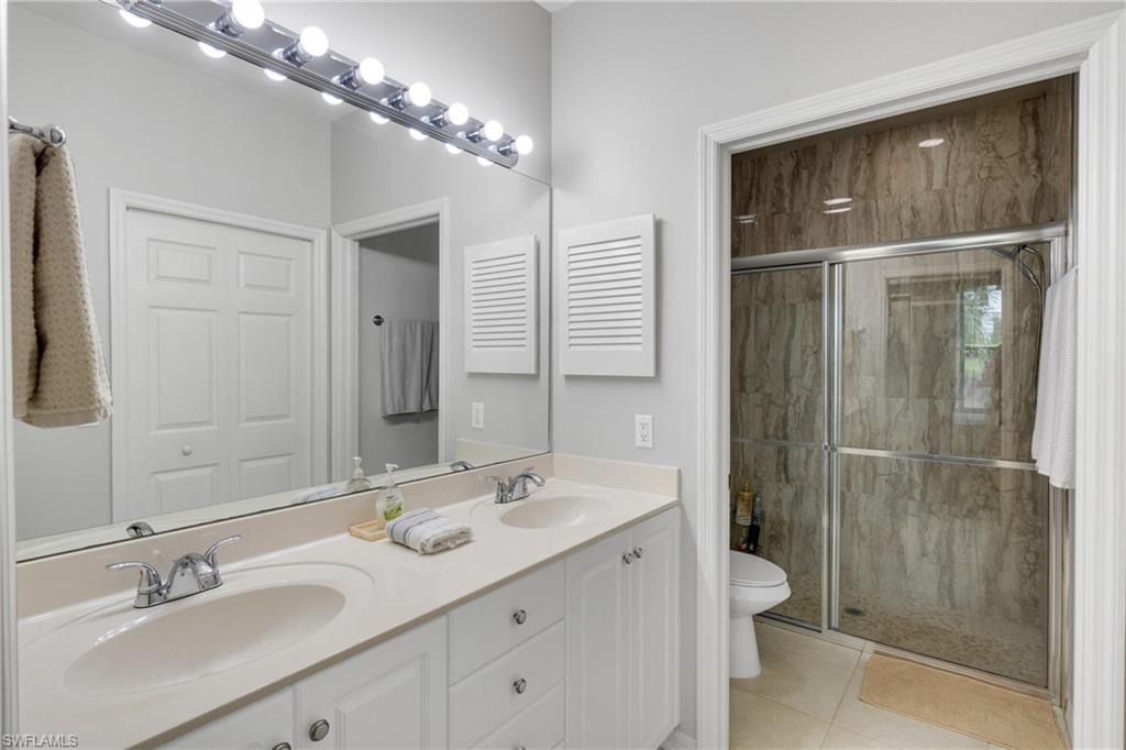 Double vanity with integrated sinks, white cabinetry, and polished chrome faucets