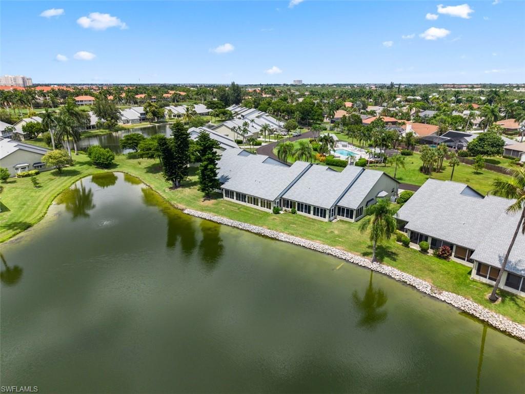 Waterfront property featuring a landscaped shoreline and mature palm trees