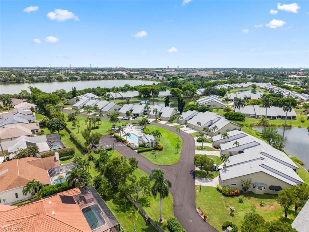 Residential community with multiple lakes, mature landscaping, and a central swimming pool with hardscaping