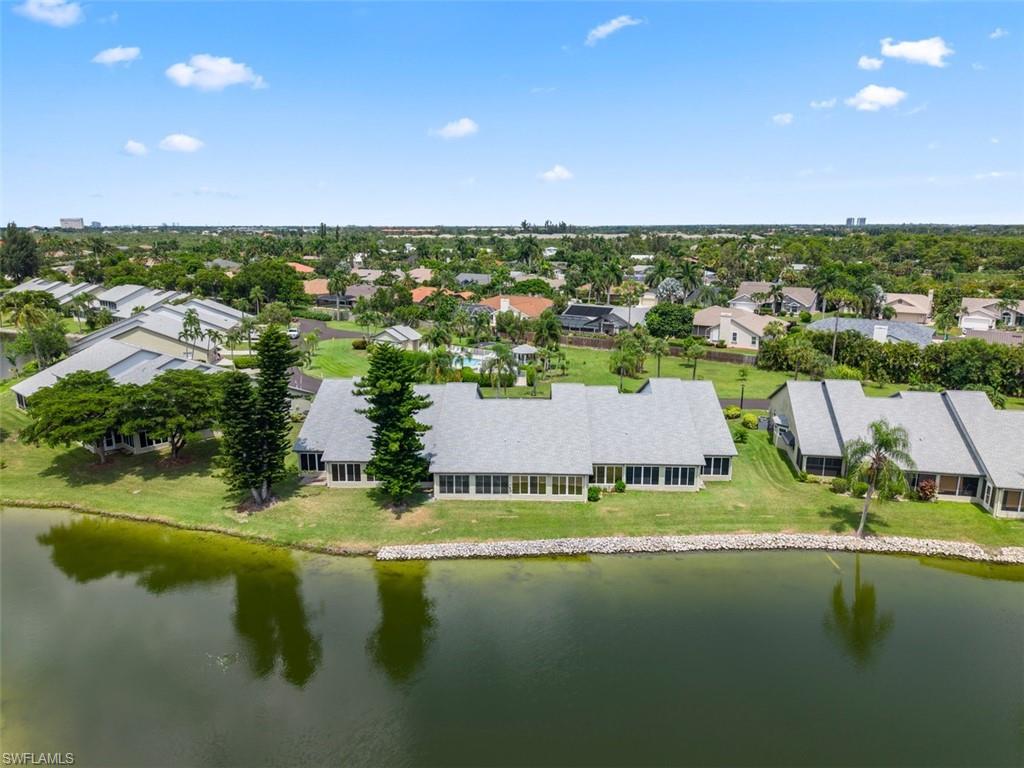 Expansive waterfront property featuring a manicured lawn and mature landscaping