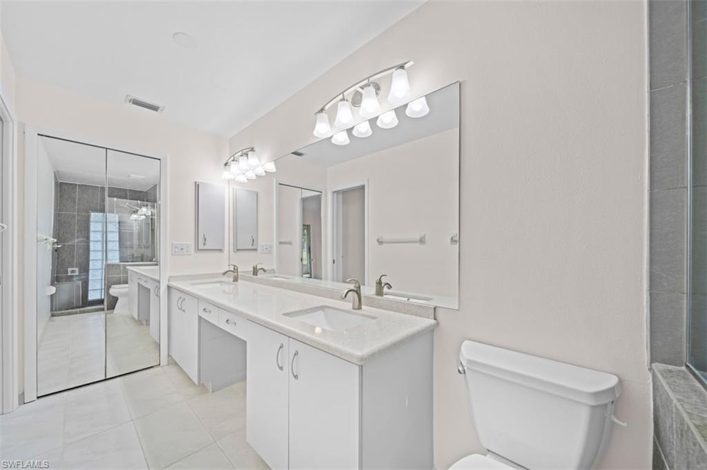 Dual vanities with white cabinetry and integrated sinks