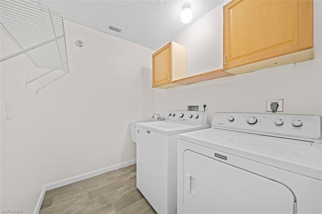 Wood-finish flooring, overhead wire shelving, and light wood-tone cabinetry