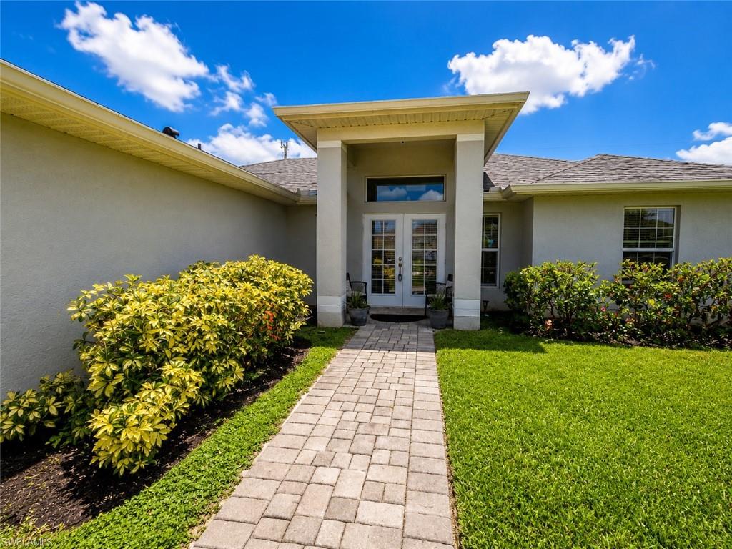 Paved walkway leading to a double-door entry with transom window