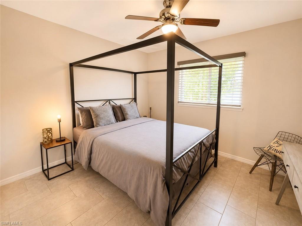Neutral tile flooring, ceiling fan with integrated lighting, window with horizontal blinds, neutral wall paint