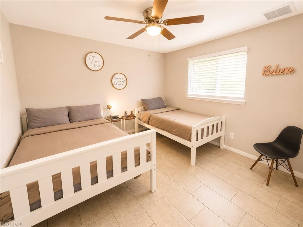 Recessed lighting, wood-finish ceiling fan, window with horizontal blinds, neutral wall tones, and light-toned tile flooring