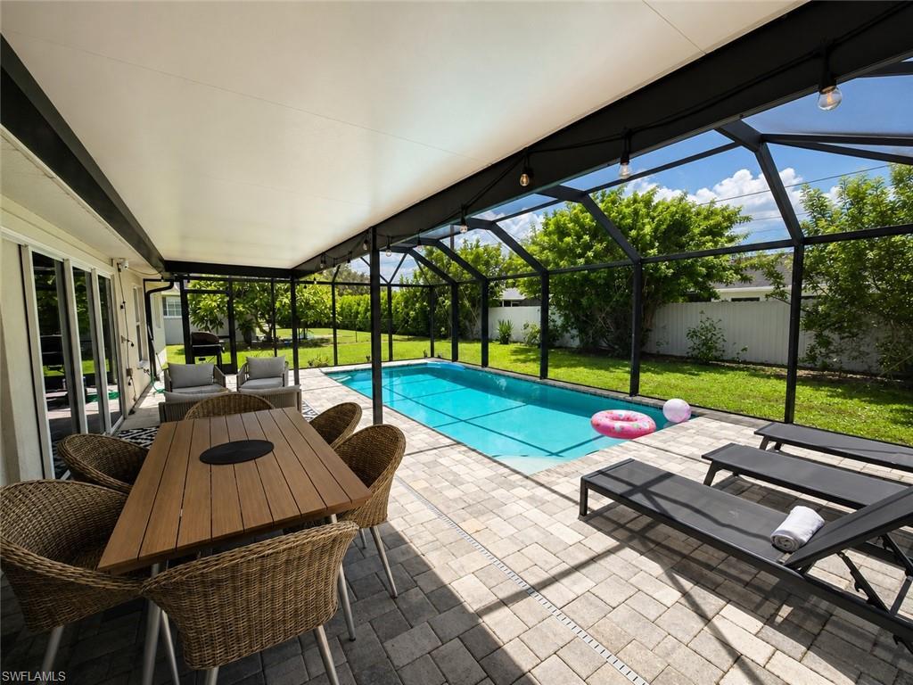 Screened-in swimming pool enclosure with paver patio