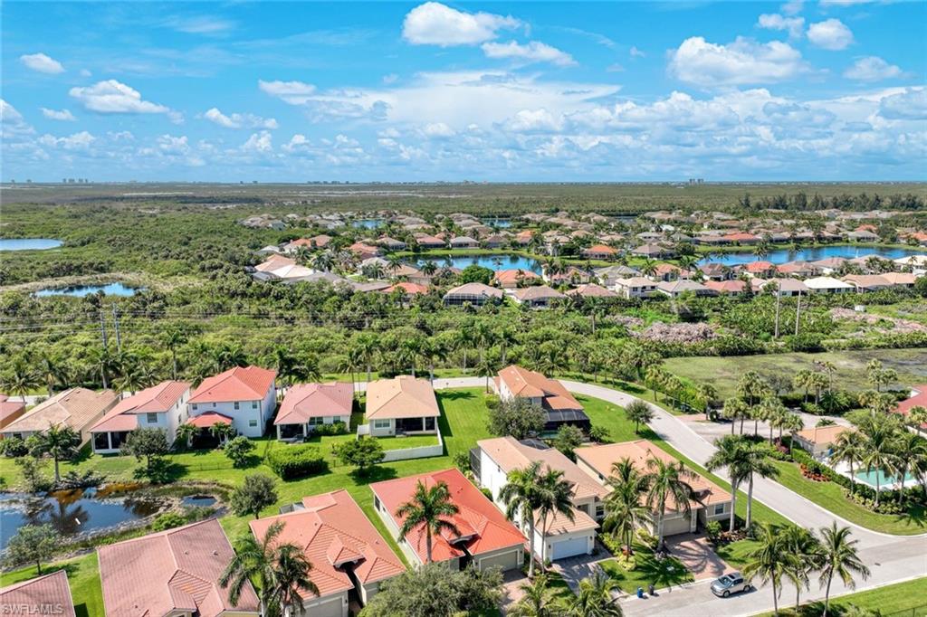 Aerial perspective featuring multiple residential structures, lush landscaping, and prominent water features