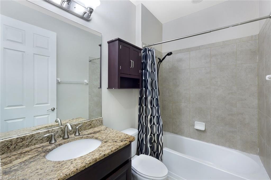 Vanity with a granite countertop, undermount sink, and brushed nickel faucet