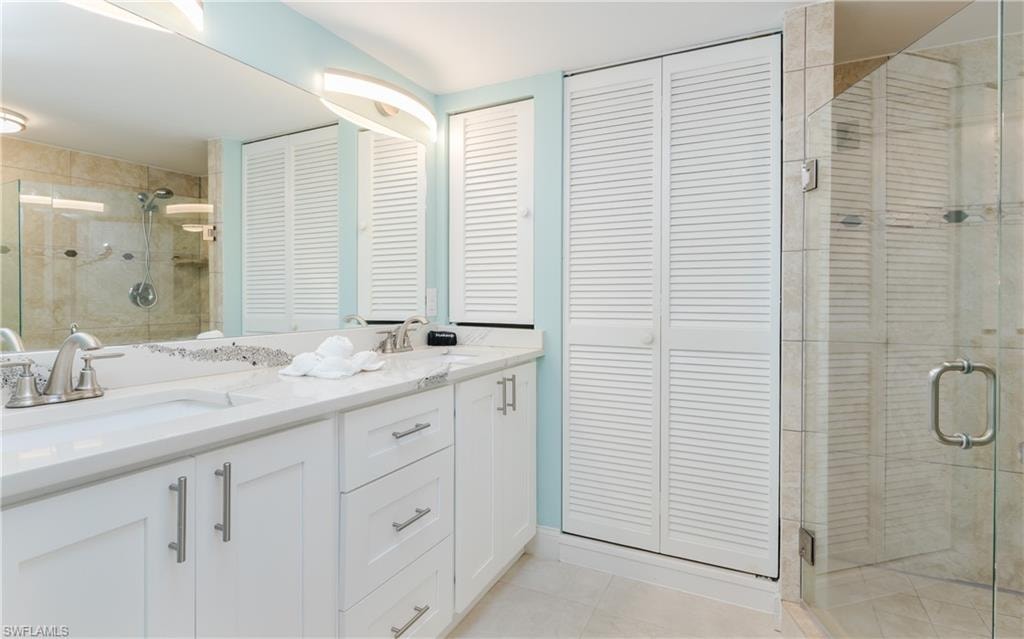 Dual vanity with white cabinetry, integrated sinks, and polished chrome fixtures