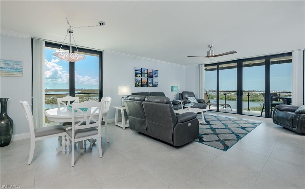 Open-concept living space featuring neutral tile flooring, a dining area, and expansive windows