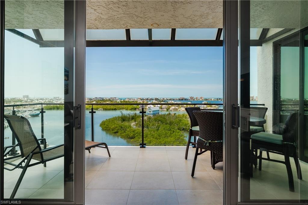 Expansive balcony featuring tile flooring and a glass railing system