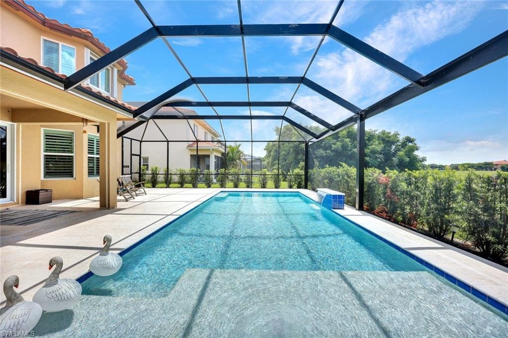 Screened-in pool enclosure featuring a  swimming pool with integrated steps,