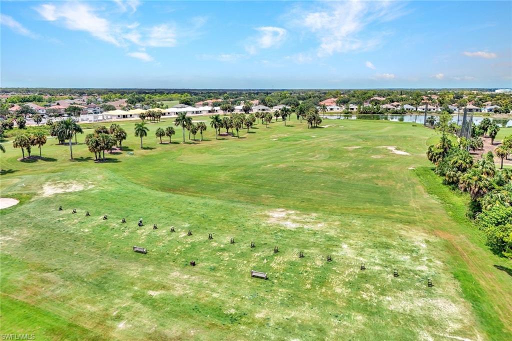 Expansive golf course landscape featuring lush green fairways and mature palm trees, 6th hole