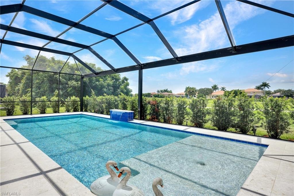 Screened-in outdoor pool featuring a water feature, an integrated shallow sun shelf