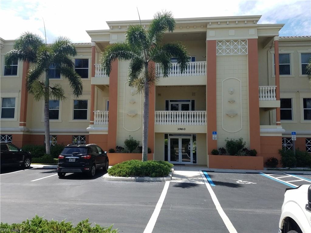 View of apartment building / complex with uncovered parking