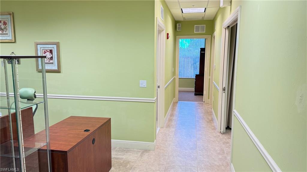Corridor featuring a drop ceiling and baseboards
