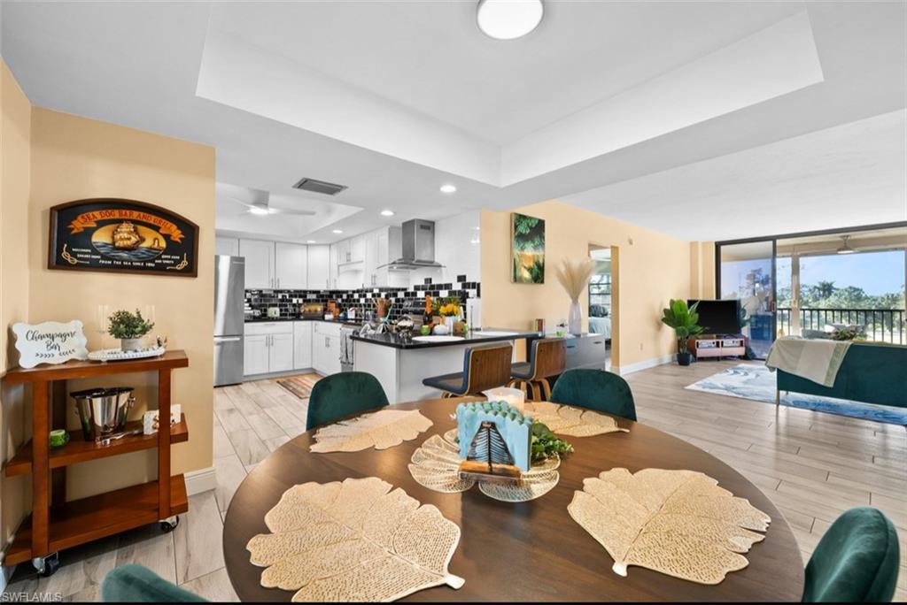 Open-concept living space featuring wood-finish flooring and a tray ceiling