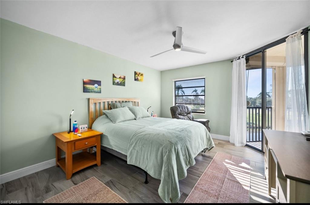Wood-finish flooring, ceiling fan, and sliding glass door leading to a private balcony