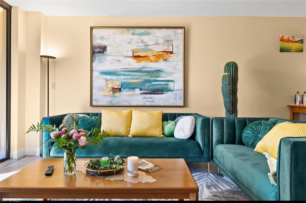 L-shaped sectional seating with velvet upholstery, wood-finish flooring, and light-toned wall paint